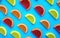 Colorful oval citrus jelly candies pattern on a blue background. Yellow, pink, red, orange round shaped marmalade.
