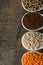 Colorful overhead view of grains in white spoon on wood