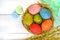 Colorful painted eggs in a nest of twigs of willow on a light background.