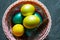 Colorful painted marble shiny Easter eggs in a basket with delicate feathers close-up. Nest with straw - Easter decoration on the