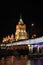 Colorful panorama of the night city with neon lights. Bridge over the river against the background of historic buildings at night