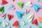 Colorful paper airplanes on pastel pink and blue colored background