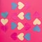 Colorful paper hearts connected by thread on red background. Flat lay