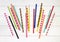 Colorful paper straws on white wooden background.