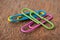 colorful paperclips on wooden desk background
