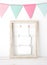 Colorful party flags hanging over white vintage wooden frame wit