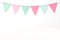 Colorful party flags hanging on white wall background, birthday