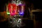 Colorful party glasses, red, blue and green, filled with champagne, cava or prosecco, on a dark and black background.