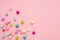 Colorful pastel beads on pink background. Girly minimalist composition