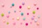 Colorful pastel beads on pink background. Girly minimalist composition