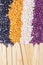 Colorful pearl polymer wax grain seed and wooden spatula stick for depilation closeup. Concept od tools for hair remove, flyer,