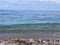 Colorful pebbles on the beach. clear transparent wave rolling on the sand. clean sea water background