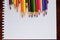 Colorful pencils and blank paper on old desk