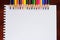 Colorful pencils and blank paper on old desk