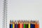 Colorful pencils and blank paper on old desk