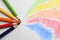 Colorful pencils with swatches on white background, top view