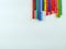 Colorful pens lined randomly on one corner of the image on white background making a frame for school, university, coloring, note