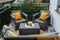 Colorful pillows, soft blanket and yellow chrysanthemum flowers on rattan garden furniture outdoors