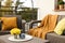 Colorful pillows, soft blanket and yellow chrysanthemum flowers on rattan garden furniture outdoors