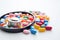 Colorful Pills in Bowl Alongside Stethoscope for Medical Examination, Stethoscope with pile of colorful antibiotic capsule pills