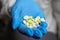 Colorful pills in the hand of a health worker. Blurred background