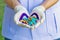 Colorful pills in heart â€“ shape on disposable glove of hand o