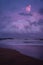 Colorful pinkish purple sunset in the Galle beach, sunlight reflected on the beach waves. Romantic scenery in island of Sri Lanka