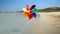 Colorful pinwheel spinning in the wind on a sandy beach, evoking the concepts of travel, summer holiday, vacation, beach tourism,