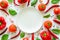 Colorful pizza ingredients pattern made of tomatoes, pepper, chili, garlic, basil and empty plate on white background.