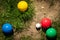 Colorful plastic boules or boccia balls are lying on a green meadow