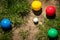 Colorful plastic boules or boccia balls are lying on a green meadow