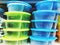 Colorful plastic bowls displayed on shelves for sale in a supermarket