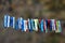 Colorful plastic clothespins in various size and shapes densely put on single rope wet from rain