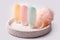 Colorful plastic containers for shampoo, hair balm and shower gel with washcloths on a marble tray. Cosmetic products for spa and