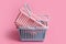 Colorful plastic shopping baskets. Empty pink and blue supermarket baskets on pink pastel background. Creative