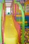 Colorful plastic slide with mesh and colorful balls in the playground, children's safety in the indoor playground