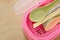 Colorful plastic soup spoon and chopsticks in pink box