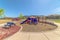 Colorful playground equipment and benches at a park with Mount Timpanogos view