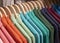 Colorful polo shirt on hang for sale in shop. Green blue polo on wooden hanger. Summer season wear in department store