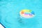 A colorful pool float bobs in tranquil water, capturing a serene summer vibe. This scene reflects leisure and the joy of