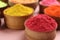 Colorful powders in wooden bowls on pink background, closeup with space for text. Holi festival celebration