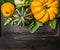 Colorful pumpkin with stem and leaves on dark wooden background