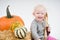 Colorful pumpkins and little baby on white background