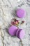 Colorful purple macaroons with flower on a light grey background. Food photo. Food photography. Simplicity. Minimalism. french