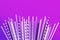 Colorful purple straws collections on pastel background.