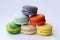 Colorful pyramid of tasty macaroons on white background, close-up