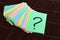 Colorful question marks written reminders tickets on wooden background