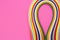 Colorful quilling, twisting paper, abstract rainbow on pink background, copy space