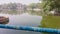 Colorful railing by a serene lake pond with urban buildings in the background on a hazy day