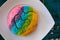 Colorful Rainbow Concha Mexican Pastry on a white plate.